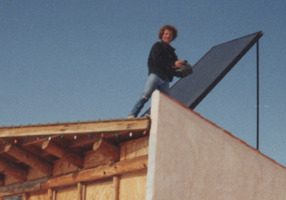 Todd Coash, president of 
NORTH STAR CONSTRUCTION & REMODELING CO. INC. CRC1330674, standing on the roof of his Durango Colorado hosue. He is installing the solar water heating system that heated the domestic hot water and floors in the house. Circa. 1994